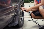 Man asia driver checking air pressure and filling air in the tires of car
