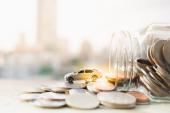 Miniature car model and Financial statement with coins. Finance and car loan, saving money for a car or material design concepts.